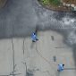 group of men applying black diamond on parking lot