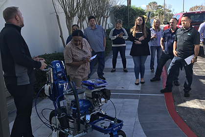 sales manager teaching other employees how to use Seal-Right Spray System